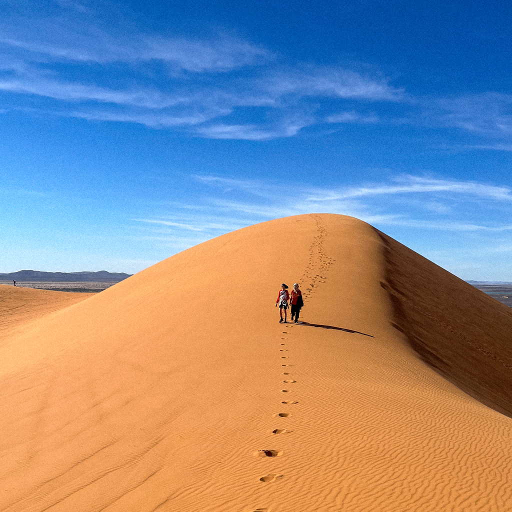 Foto de unas manos tocando una roca dentro del agua.